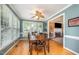 Bright dining room with hardwood floors, a ceiling fan, and a view into the living room with a fireplace at 104 Goldleaf Ct, Angier, NC 27501