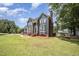 Charming blue two-story home boasts a landscaped front yard, brick chimney, and inviting entrance at 104 Goldleaf Ct, Angier, NC 27501