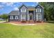 Charming blue two-story home boasts a landscaped front yard, brick foundation, and inviting entrance at 104 Goldleaf Ct, Angier, NC 27501