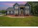 Charming blue two-story home boasts a landscaped front yard, brick foundation, and inviting entrance at 104 Goldleaf Ct, Angier, NC 27501
