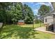 Lush backyard with a well-maintained lawn, wooden shed, and shaded pergola area at 105 Rolling Stone Ct, Sanford, NC 27332