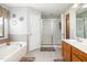 Bright bathroom with a soaking tub, glass-enclosed shower, and wooden vanity at 105 Rolling Stone Ct, Sanford, NC 27332
