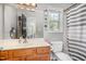 Bathroom with wood vanity, large mirror, toilet, and shower with striped curtain at 105 Rolling Stone Ct, Sanford, NC 27332