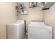 Functional laundry room with white washer, dryer, and overhead storage shelves at 105 Rolling Stone Ct, Sanford, NC 27332