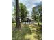 View of gray house through trees in the backyard at 108 Herbert St, Durham, NC 27703