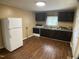 Bright kitchen features wood flooring, black cabinets, and modern white refrigerator at 108 Herbert St, Durham, NC 27703