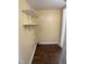 A compact laundry room with built-in shelving and dark wood-look flooring at 108 Herbert St, Durham, NC 27703