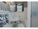 Bathroom featuring white fixtures, black and white tile flooring, and striped wallpaper at 1110 Edgewood Ave, Burlington, NC 27215