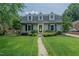 Charming home with dormer windows, a green door and lush landscaping at 1110 Edgewood Ave, Burlington, NC 27215