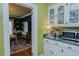 White cabinets, green walls, and view of dining room from the kitchen at 1110 Edgewood Ave, Burlington, NC 27215