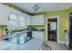 Charming kitchen with white cabinets, green walls, and view of dining room at 1110 Edgewood Ave, Burlington, NC 27215