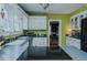 Charming kitchen with white cabinets, green walls, and view of dining room at 1110 Edgewood Ave, Burlington, NC 27215
