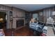 Living room featuring a brick fireplace, wood-paneled walls, and built-in shelving at 1110 Edgewood Ave, Burlington, NC 27215