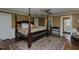 Primary bedroom with a four-poster bed, ceiling fan, and hardwood floors at 1110 Edgewood Ave, Burlington, NC 27215