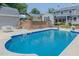 Inviting backyard pool with concrete patio, lush landscaping, and access to other areas of the yard at 1110 Edgewood Ave, Burlington, NC 27215
