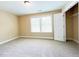 Bright bedroom with large window, neutral paint, and carpet, offering a relaxing space at 115 Ballyliffen Ln, Cary, NC 27519