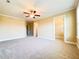Bedroom with a ceiling fan, neutral carpet, and walk-in closet, providing comfort and storage at 115 Ballyliffen Ln, Cary, NC 27519