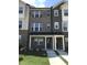 Townhouse exterior showcasing a brick facade, covered porch, and well-maintained landscaping at 115 Ballyliffen Ln, Cary, NC 27519