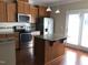 Bright kitchen boasts an island, stainless steel appliances, ample cabinet space and adjacent access to a patio at 115 Ballyliffen Ln, Cary, NC 27519