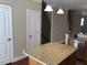 Kitchen features an island, offering additional workspace and a gathering spot, complemented by nearby doors and stairs at 115 Ballyliffen Ln, Cary, NC 27519