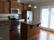 Bright kitchen boasts an island, stainless steel appliances, ample cabinet space and adjacent access to a patio at 115 Ballyliffen Ln, Cary, NC 27519
