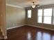 Bright living room with natural light, ceiling fan, and hardwood flooring at 115 Ballyliffen Ln, Cary, NC 27519