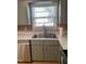Close up of stainless steel kitchen sink and window with matching countertops and gray cabinets at 1210 Fayetteville St, Smithfield, NC 27577