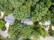An aerial view of a home nestled among lush trees with surrounding neighborhood streets and houses at 1218 Chimney Hill Dr, Apex, NC 27502