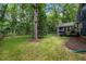 Expansive backyard featuring lush green grass, mature trees, and a charming screened-in porch at 1218 Chimney Hill Dr, Apex, NC 27502
