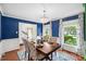 Well-lit dining room showcasing hardwood floors, blue walls, and large windows at 1218 Chimney Hill Dr, Apex, NC 27502