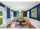Elegant dining room features blue walls, hardwood floors, and stylish furnishings with natural light at 1218 Chimney Hill Dr, Apex, NC 27502
