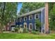 Attractive two-story house with a manicured lawn, flowering shrubs, and a classic brick chimney at 1218 Chimney Hill Dr, Apex, NC 27502