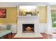 Living room fireplace featuring a white brick surround, mantel, and gas logs with hardwood flooring at 1218 Chimney Hill Dr, Apex, NC 27502