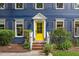 Close-up of a bright yellow front door with white trim, brick steps, and manicured landscaping at 1218 Chimney Hill Dr, Apex, NC 27502