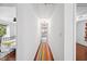 Upstairs hallway with hardwood floors and natural light leading to multiple rooms at 1218 Chimney Hill Dr, Apex, NC 27502