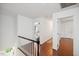 Upstairs hallway featuring hardwood floors, white walls, and views of the bedrooms at 1218 Chimney Hill Dr, Apex, NC 27502
