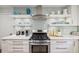 Kitchen features a stainless steel range, white countertops, and floating shelves at 1218 Chimney Hill Dr, Apex, NC 27502