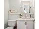 Cozy powder room featuring white wainscoting, quartz countertop, decorative mirror and modern fixtures at 1218 Chimney Hill Dr, Apex, NC 27502