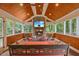 Relaxing screened porch with a stone fireplace, comfortable seating, and wood paneled ceiling at 1218 Chimney Hill Dr, Apex, NC 27502