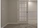 Basement area featuring neutral paint, carpet flooring, white trim, and a door with glass panels at 1227 Bessie Ct, Wake Forest, NC 27587