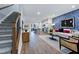 Open-concept living room with hardwood floors, staircase, modern kitchen, and elegant decor at 1227 Bessie Ct, Wake Forest, NC 27587