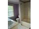 Bright bathroom with shower/tub combo, granite sink, and large window at 126 Riverglade Dr, Clayton, NC 27527