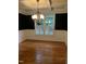Inviting dining room with dark walls, wood floor, wainscoting, and a stylish chandelier at 126 Riverglade Dr, Clayton, NC 27527