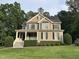 Charming two-story home featuring a covered front porch, black shutters, and a well-manicured lawn at 126 Riverglade Dr, Clayton, NC 27527
