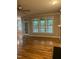 Open living room with hardwood floors, a door to the patio, and an entry to the kitchen at 126 Riverglade Dr, Clayton, NC 27527