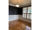 Cozy living room with dark accent walls, white trim, hardwood floors and plantation shutters at 126 Riverglade Dr, Clayton, NC 27527