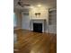 Bright living room with built-in shelving, a fireplace, hardwood floors, a ceiling fan, and large windows at 126 Riverglade Dr, Clayton, NC 27527