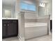 A bathtub with neutral tile backsplash is flanked by dark wood vanities, offering comfort and style at 13 Knotty Pine Lane, Clayton, NC 27520