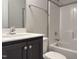 Modern bathroom features a dark vanity, white countertops, and a shower-tub combination at 13 Knotty Pine Lane, Clayton, NC 27520