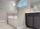 Bright bathroom with a soaking tub and a dark wood vanity, offering a relaxing and stylish space at 13 Knotty Pine Lane, Clayton, NC 27520
